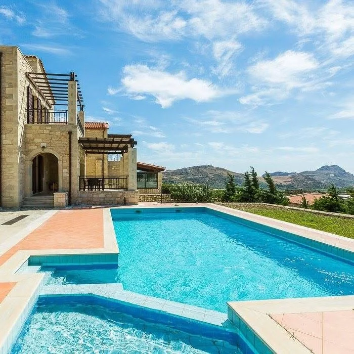 Pool and stone villa by day