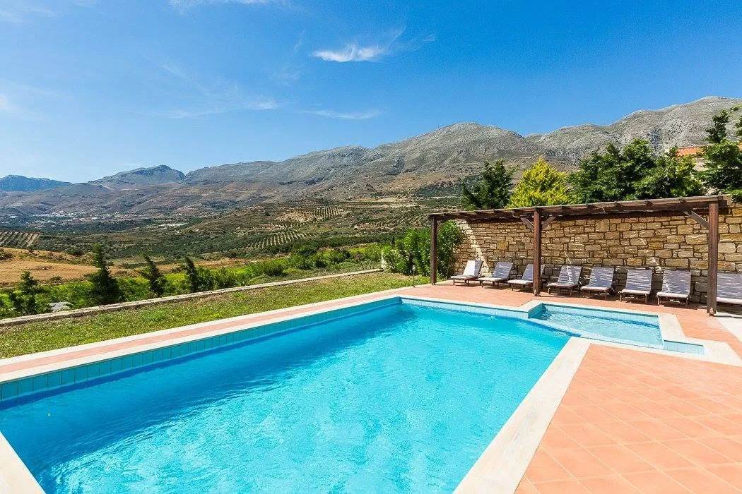 Pool and stone villa by day