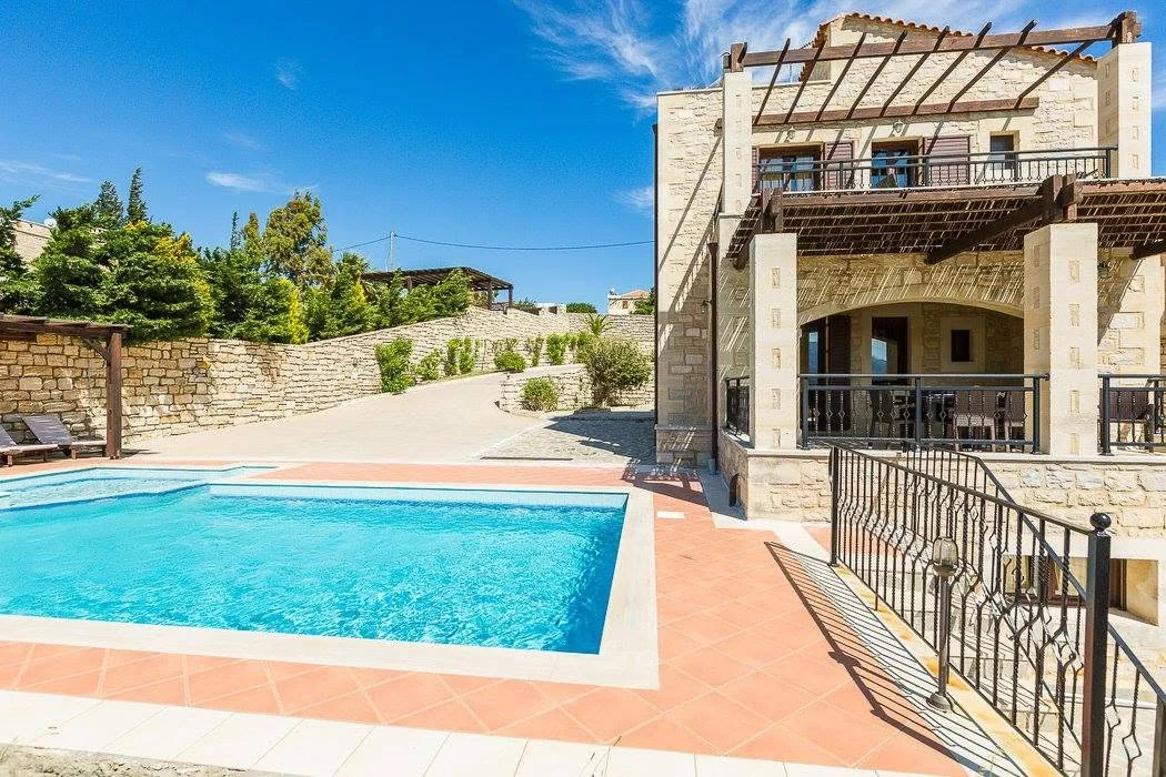 Pool and stone villa by day