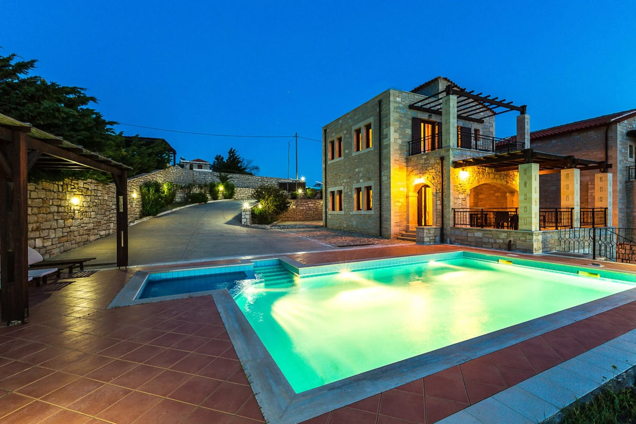 Villa Thalia, stone terraces and the glowing private pool at dusk