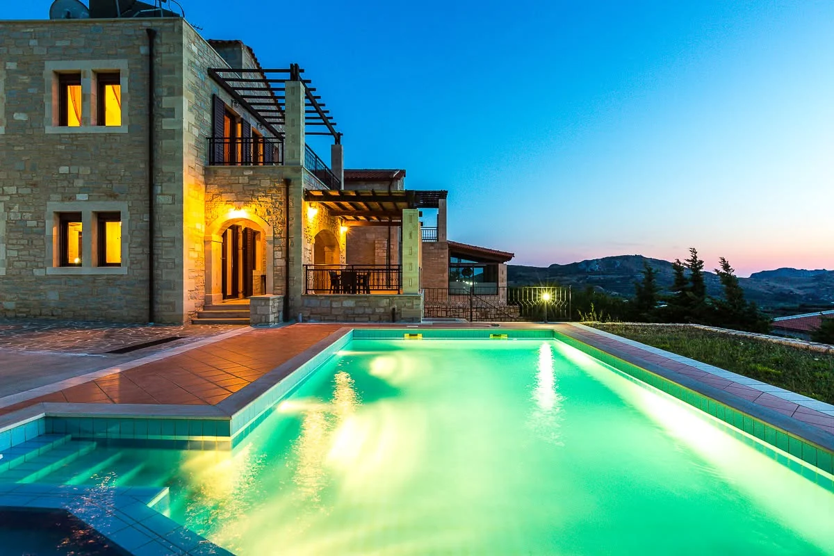 Villa Thalia lit at dusk with the pool glowing