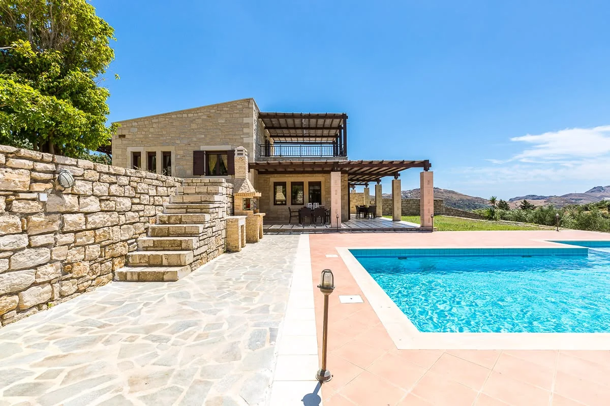 Pool and stone villa by day