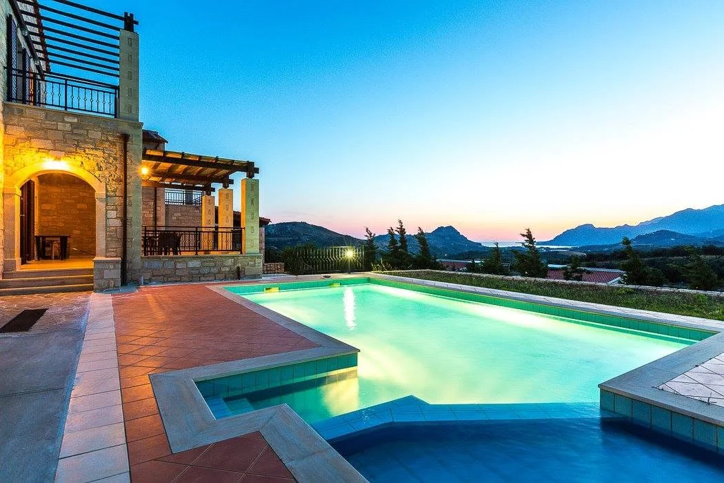 Villa Thalia lit at dusk with the pool glowing