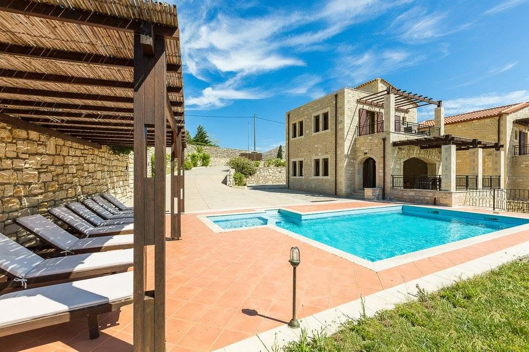 Pool and stone villa by day