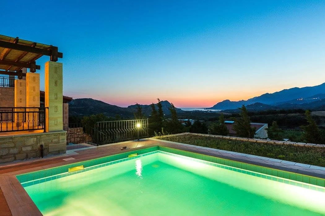 Villa Thalia lit at dusk with the pool glowing