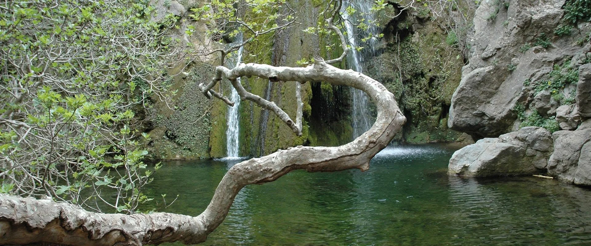 Waterfall, rocks and trees in a Cretan gorge