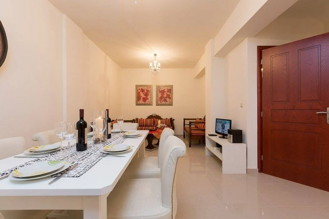 Living and dining area with stone walls and wood-beamed ceiling