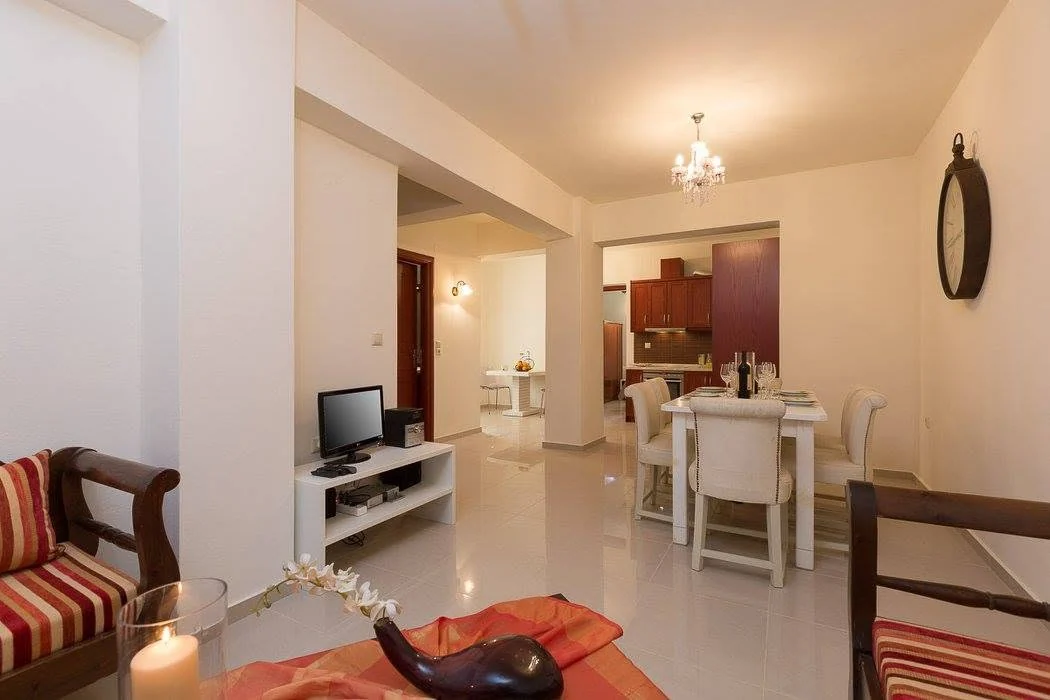 Living and dining area with stone walls and wood-beamed ceiling