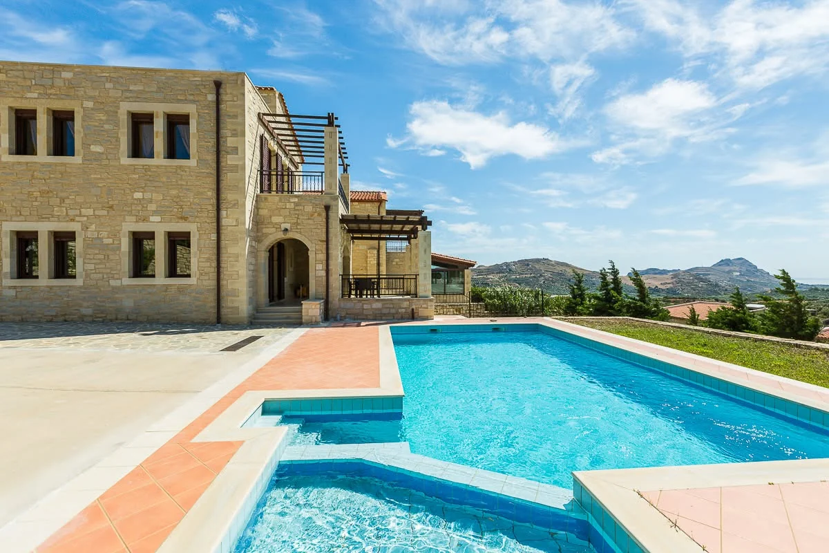 Pool and stone villa by day